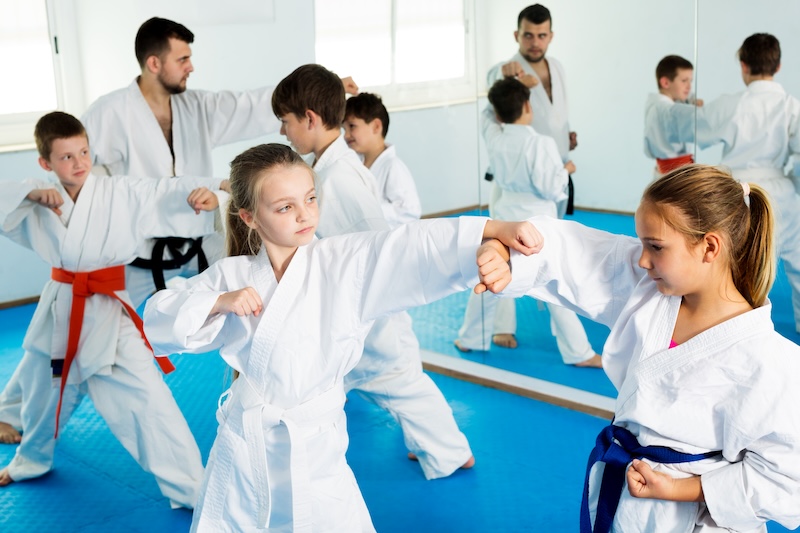man in white and black jacket and pants sitting on black floor